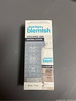 Photo of a boxed skincare product labeled bye bye blemish Volcanic Ash Drying Lotion with branding and claims about volcanic ash, salicylic acid, and overnight results.