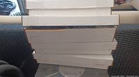 Stack of four white cardboard long boxes