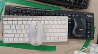 Top view showing Sparin white wireless keyboard and mouse placed on top of Logitech black keyboard and mouse.