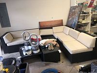 Wide view of six-piece sectional showing black wicker modules and cream cushions