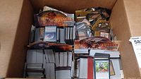 Cardboard box containing multiple stacks of Magic: The Gathering cards separated by branded display dividers