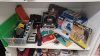 Wide shot showing all items in lot: tools such as level, hammer, measuring tape, wire stripper, utility knife, putty knife, and boxed Kreg Jig kits.