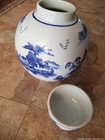 Photo of the blue and white ceramic ginger jar with detailed Chinese scenic landscape artwork.