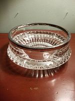 Full view of cut crystal dessert bowl with silver rim showing overall shape and clear detailing of cut glass design.