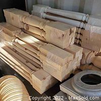 Stack of unfinished wood newel posts and spindles in storage area