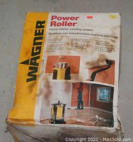 Photo of Wagner Power Roller home interior painting system in its original box showing product name, brand, and illustrative images of the device in use.