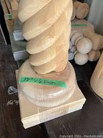 Photo of the base and lower part of the spiral fluted wooden column with a label showing 33" height and 6" diameter.