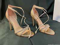 Front and side view of the gold sparkly heels showing rhinestone details on the front straps and ankle strap tie closure.