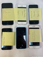 Top view of six iPhones with Post-it notes describing individual defects including locked activation, broken home button, and inability to factory reset