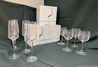 Full view of all 16 glasses with original Sierra packaging boxes stacked behind them on black cloth background