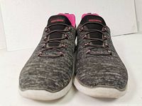 Front view of the Skechers women's running shoes showing dark gray textured fabric upper with black and pink accents.