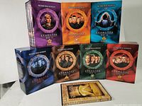 Front view of boxed sets showing cover artwork for Stargate SG-1 seasons 1 through 7 and Ultimate Edition Extended Cut DVD sets.