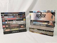 Front stacked view of DVD collection lot showing titles in two stacks including P-47 Thunderbolt, The Century of Warfare, A Bridge Too Far, Mission: Impossible, Apocalypse Now, Saving Private Ryan, and others.