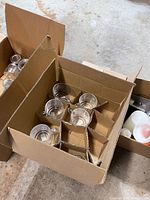 Box with clear glass coffee mugs placed in divided cardboard compartments showing 6 mugs.