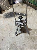 Similar front angle photo of the Nemco professional produce slicer showing the full upright metal frame and black knob at top