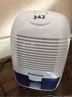 Front view of Pro Breeze mini dehumidifier PB-03-CA showing air intake grille, water tank, and model branding.