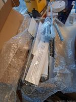 Collection of knives and two knife sharpeners wrapped in bubble wrap inside a box.