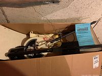 Overall contents of metal detector disassembled in box with manual visible