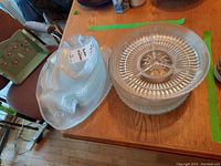 Stacked round glass serving bowls and round platter next to large fish platter