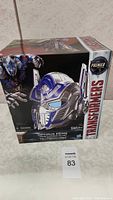 Front of the new 2016 Transformers Optimus Prime voice changer helmet box showing helmet image and brand logos