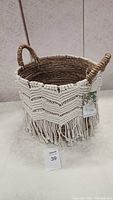 Front view of the basket showing macrame decoration and handles