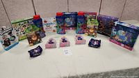 Wide view of entire lot layout showing multiple kids toys, bubble bottles, boxed puzzles, small soaps, and Disney puzzle box.