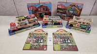 Shows entire lot including packaging of wooden toys, floor puzzles, and sticker sets.