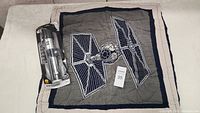 Star Wars Darth Vader Light Saber toy in original packaging next to a quilted pillow sham with a large embroidered and printed TIE Fighter design.
