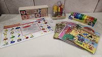 Overview of toy lot showing number puzzles, phonics mat, condiment set, counting caterpillar, and sticker packs