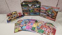 Full view of dinosaur figurines in wooden display case, 48-piece floor puzzle, and dinosaur puffy sticker sheets laid out