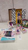 Wide shot showing Barbie doll in box, nail pen set, Bayala unicorn, Disney princess dolls and Pop Animation Majin Buu figure