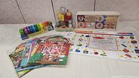Full lot with counting caterpillar, condiment set in front, number puzzles boxed, learning mat laid out, and puffy stickers.
