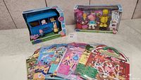 Overview photo showing two boxed Peppa Pig toys and multiple packets of Melissa & Doug puffy stickers laid out in front