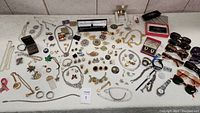 Overview of all jewelry pieces and sunglasses laid out on table