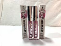 Two Buxom Full-On Lip Cream lip gloss tubes and their boxes, showing front view and branding.