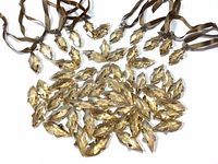 Top-down view of an assortment of amber Swarovski crystal pieces laid out on white background, some attached to brown ribbons for hanging.