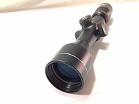 Close angled photo showing the large 44mm front lens and part of the scope barrel with matte black finish