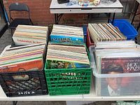 Multiple crates filled with approximately 300 vinyl LP records in sleeves, assorted genres.