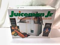 Closed original box of Juiceman Jr. Automatic Juice Extractor showing branding and product image on the front.