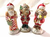 Front view of three hand painted Santa Claus figurine Christmas ornaments labeled 1923 Mexico, 1925 USA, and 1930 Canada.