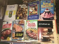 Cookbooks with various cooking themes including corn oil, muffins, pasta, summer foods, freezer meals, salads, desserts, and coffee recipes.