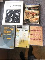 Ten paperbacks arranged in two photos on carpeted floor, covers visible showing various titles and topics.