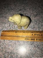 Top view of small gray elephant figurine next to ruler showing size about 2 inches