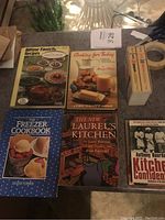 Full lot arranged on table showing all books and two small boxed items.