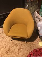 Front view of small yellow swivel chair showing curved back, cushion seat, and metal legs.