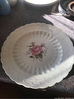 Top view of the 10 inch white porcelain Spode plate showing Billingsley Rose floral pattern in center with embossed scalloped edges.