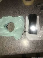 Polished chrome tub faucet handle and fixture part on countertop with packing materials