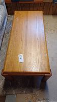 Top view of the solid wood coffee table showing overall shape and natural oak finish with some wear.