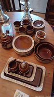 Full view of Gerzit German dishware set laid out on wooden table showing plates, mugs, bowls, trays, sugar bowl, and creamer.