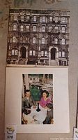 Photo showing two Led Zeppelin vinyl record album covers, one being the debut album with a building facade and the other the album Presence.